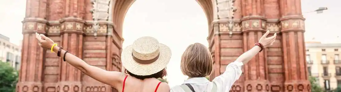 Dos turistas frente al Arco del Triunfo en Barcelona